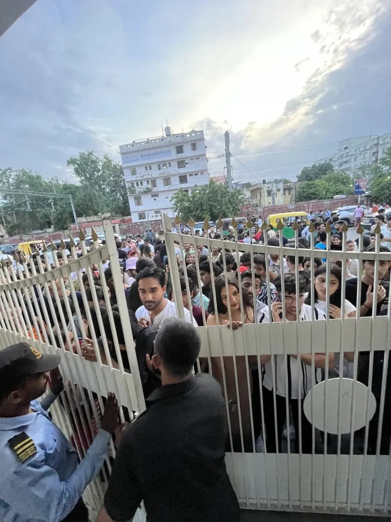 A crowd pressed up against the venue gates waiting to get into a HopShop night, security holding the entrance.